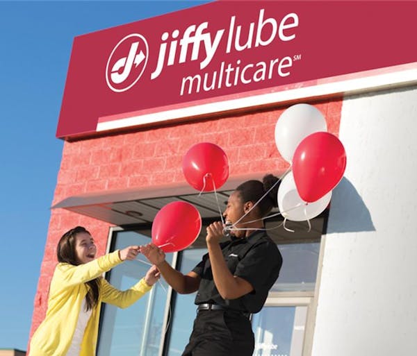Employee giving balloons to child