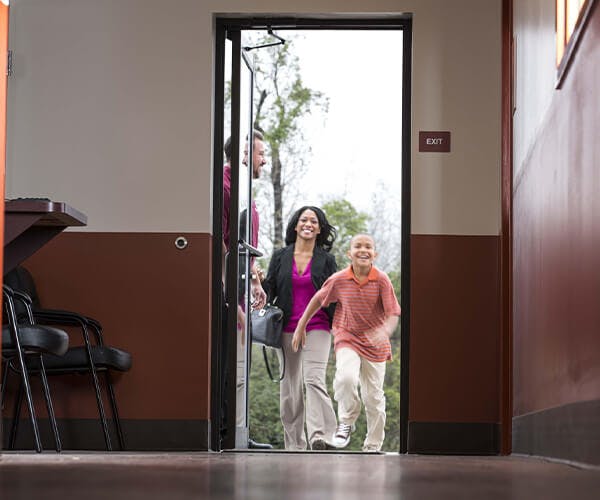 Jiffy Lube employee holding door open for family