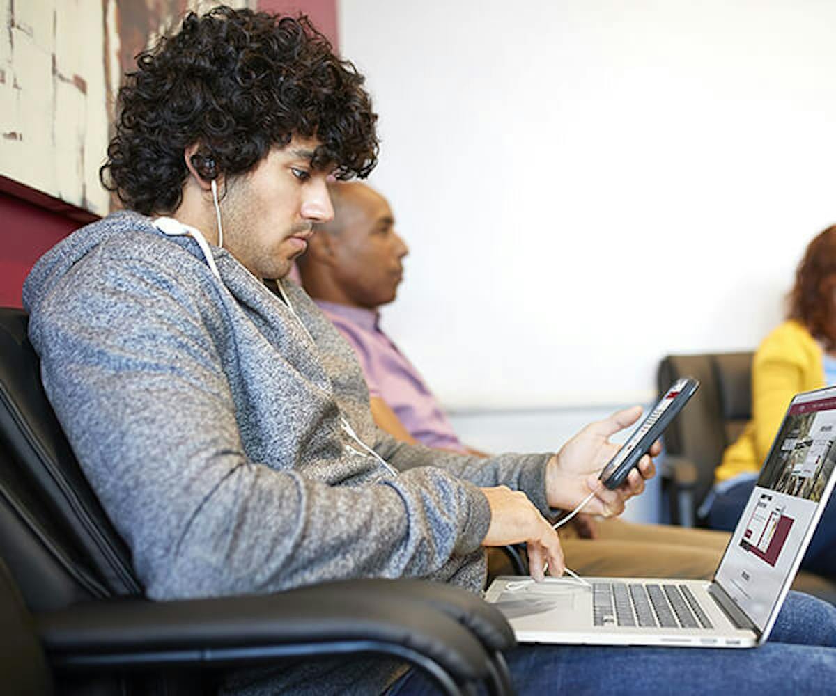 Man on phone and laptop in waiting room