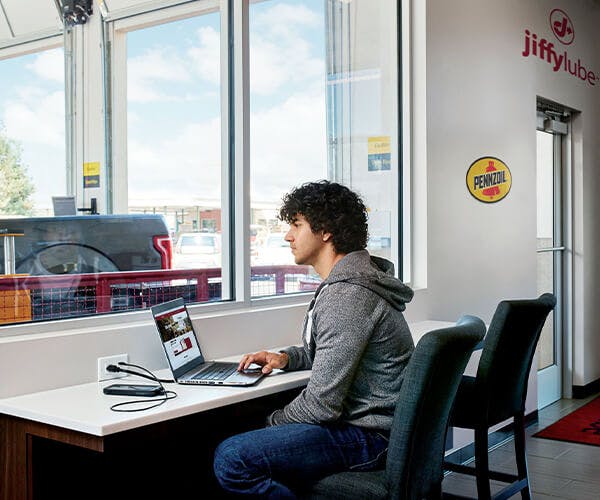 Man on laptop in waiting room