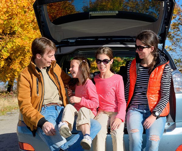 Family sitting in trunk during the fall