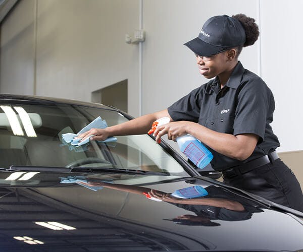 Jiffy Lube employee cleaning a windshield