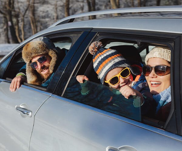 Family sitting in vehicle during winter