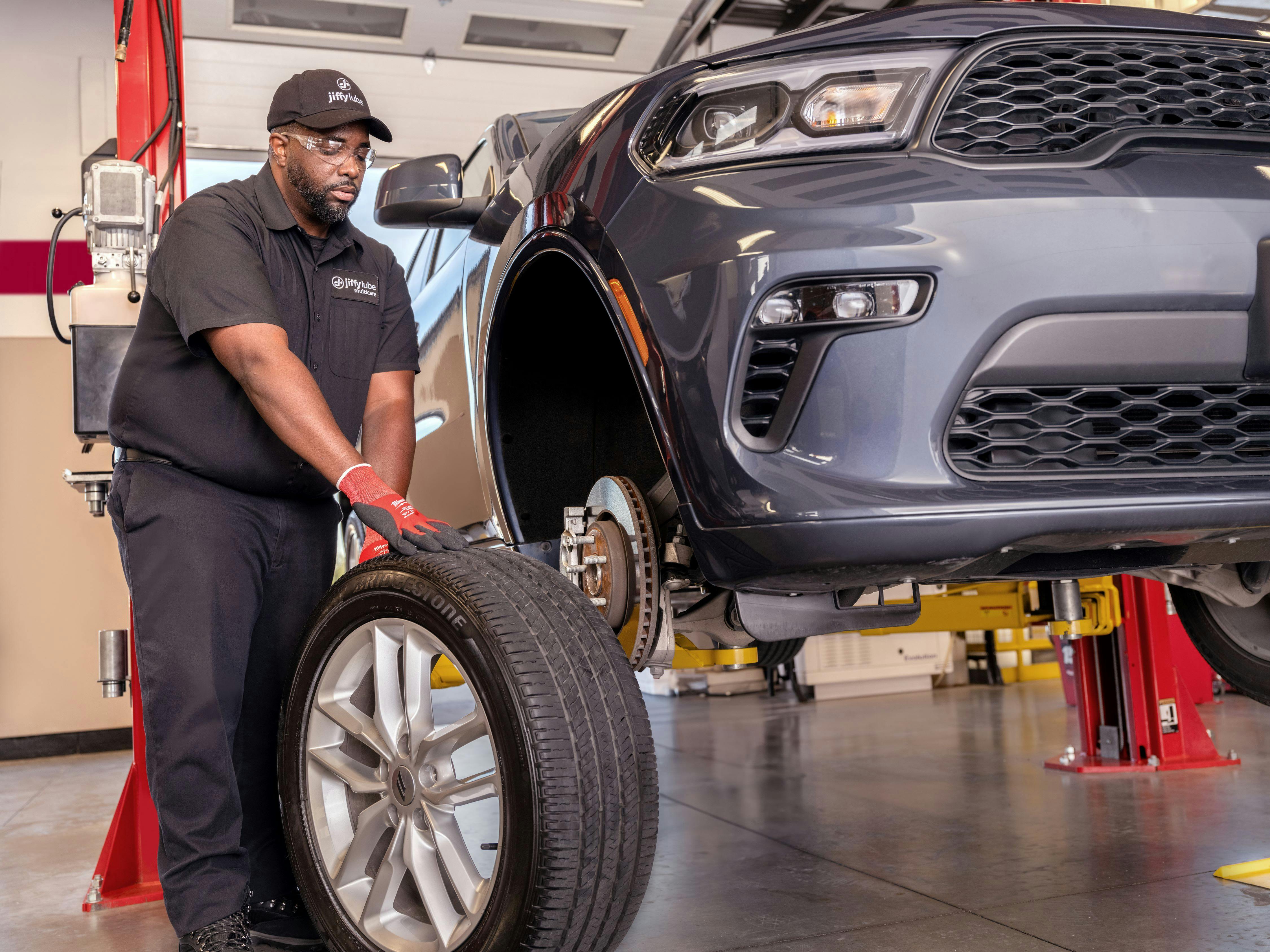 Jiffy Lube technician moving tire