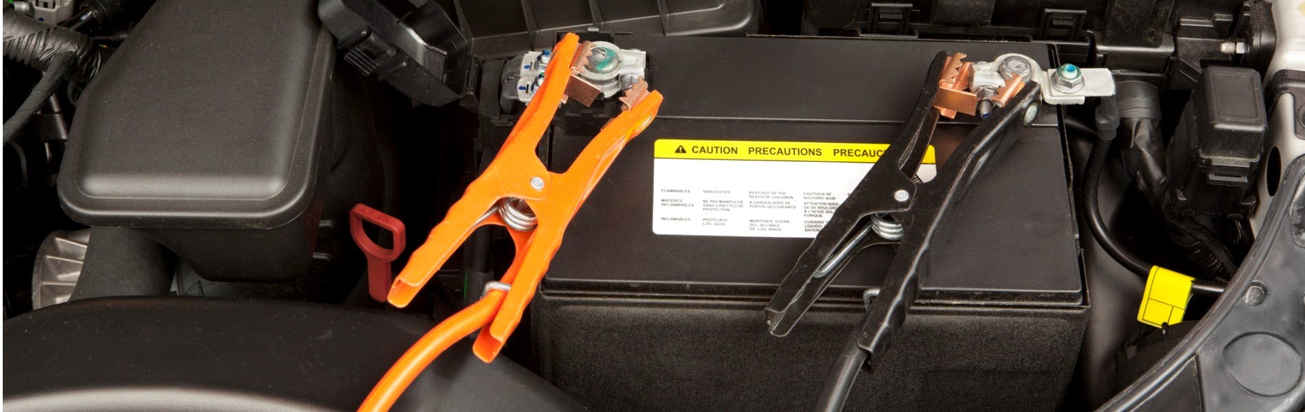 Cables connected to a car battery terminals for a testing a battery's strength