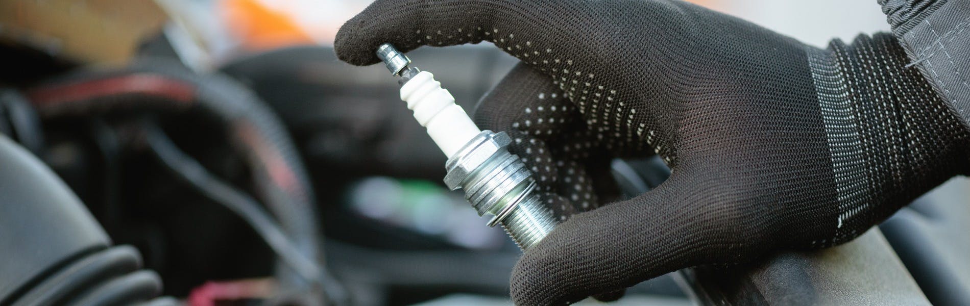 Close up of a technician holding a spark plug