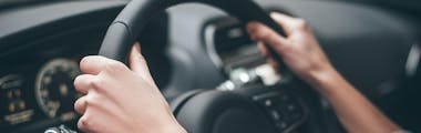 Close up of a steering wheel while someone is driving 