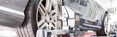 A close up view of a tire alignment service being performed