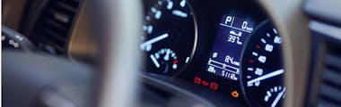 modern car dashboard with multiple dashboard warning lights on, including the check engine light and the change oil light