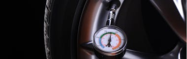 checking tire pressure with a tire pressure gauge