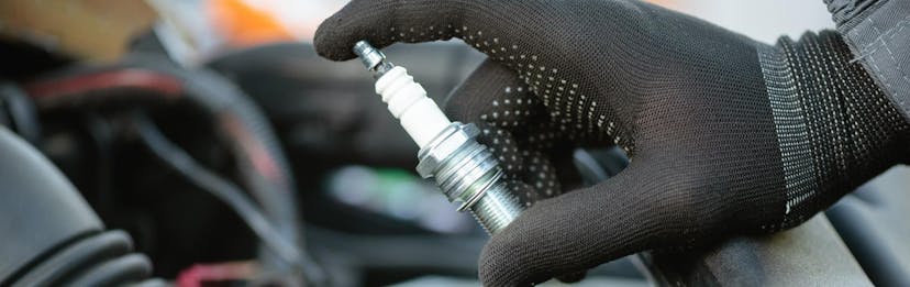 Close up of a technician holding a spark plug
