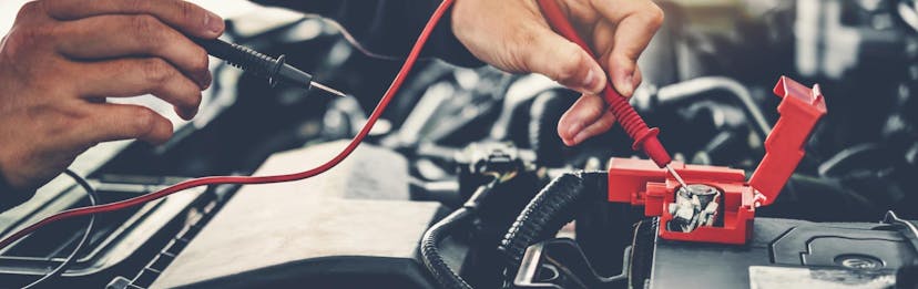A Jiffy Lube technician checking a car battery