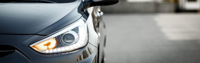 A close up of a vehicle's front headlight and blinker
